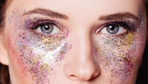 Close do rosto de uma mulher com maquiagem brilhante e glitter ao redor dos olhos, servindo de alerta para os cuidados oftalmológicos durante o Carnaval em Botafogo, Rio de Janeiro.